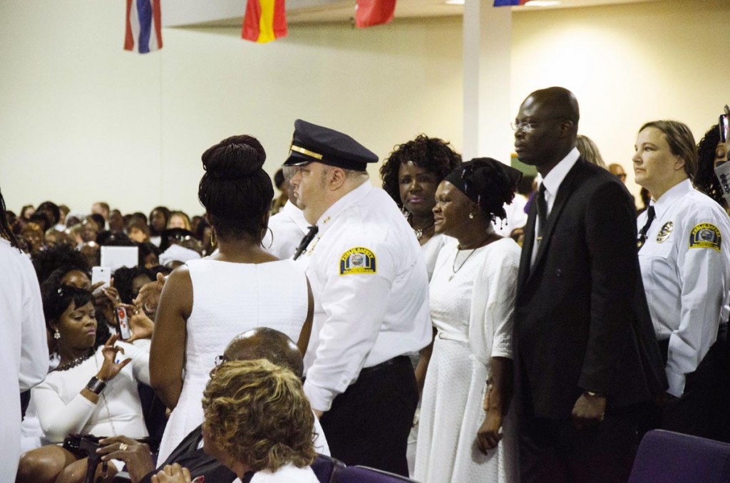 Security and family escort Louise Karluah (in black headscarf), the biological mother to the late 10-year-old Barway Collins, into Shiloh Temple International Ministries in Minneapolis on May 2, 2015, for her son's funeral. The funeral was exactly three weeks after his body was found on the Mississippi River on Saturday, April 11. Louise Karluah had just arrived from Liberia three days prior to the funeral Barway's father, Pierre Collins, was taken into custody two days after Barway was found and charged with the murder of his son. Photo: Kaamil Haider/Mshale