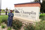 Samuel Mwangi, a Champlin City Council Ward 4 candidate, stands beside the Champlin Municipal Center sign in Champlin, Minnesota.